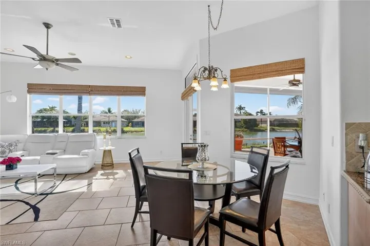 Dining room with a ceiling fan, plenty of natural light, recessed lighting, light tile patterned floors, and a chandelier
