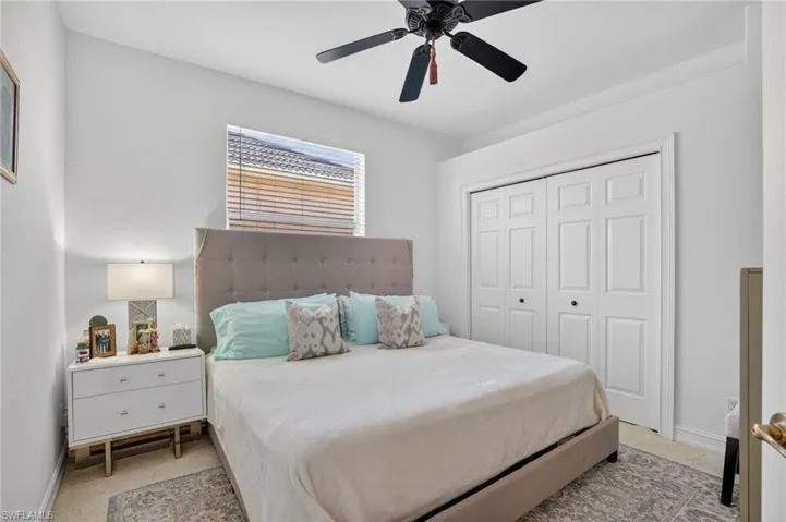 Bedroom featuring ceiling fan, a closet, and light carpet
