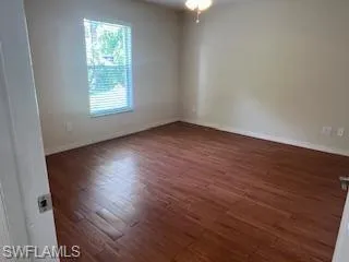 Empty room with dark hardwood / wood-style floors