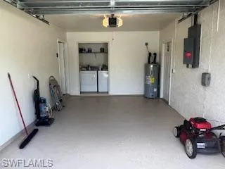 Garage with washer and dryer, a garage door opener, and water heater