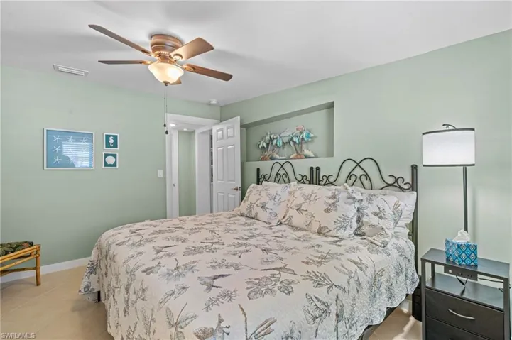 Bedroom with baseboards, visible vents, and ceiling fan