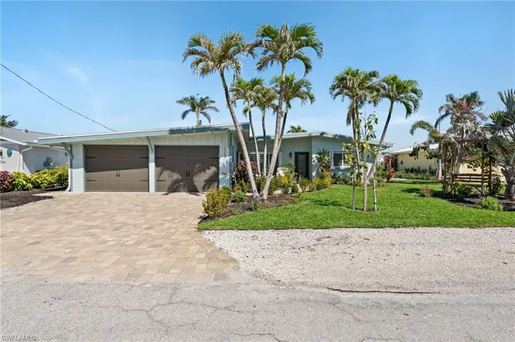 View of front of house with an attached garage, decorative driveway, and a front yard virtually enhanced image