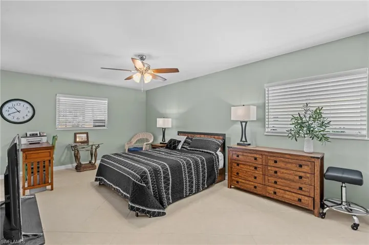 Bedroom with tile patterned flooring, baseboards, and a ceiling fan