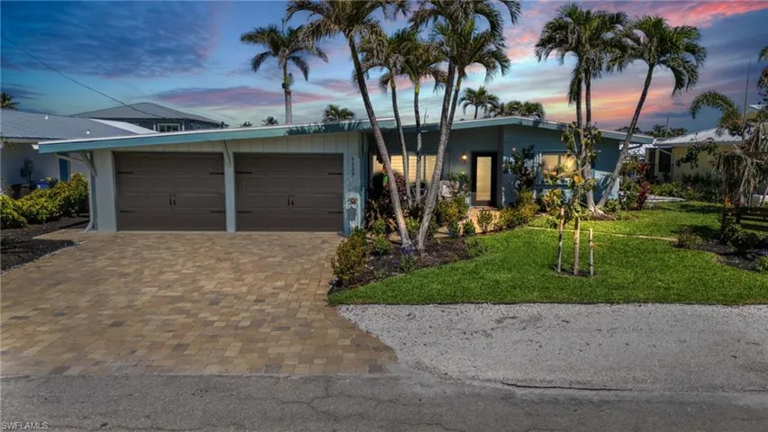 Mid-century inspired home with a yard, decorative driveway, and an attached garage - VIRTUALLY ENHANCED