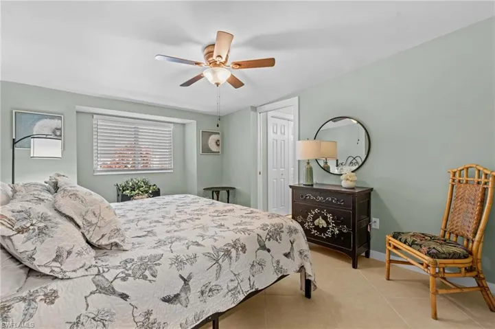 Tiled bedroom featuring a ceiling fan, a closet, and baseboards