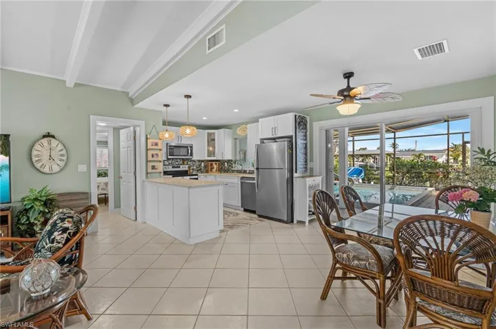 Kitchen featuring light tile patterned floors, appliances with stainless steel finishes, visible vents, and tasteful backsplash