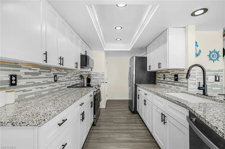 Kitchen complete with disposal, fridge, range, dishwasher, microwave with recessed lighting. Pantry at end of kitchen.
