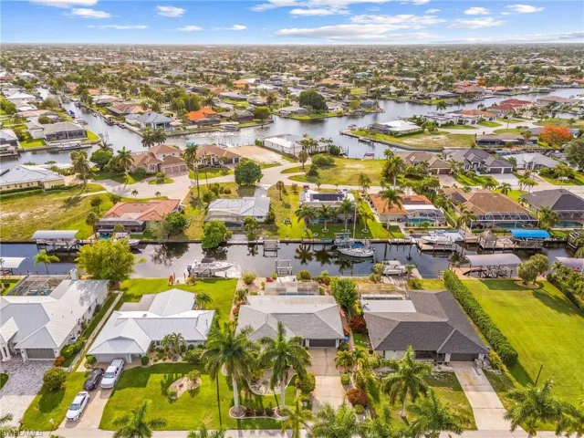 Residential neighborhood featuring extensive canal systems, mature palm trees, and multiple properties with private boat docks