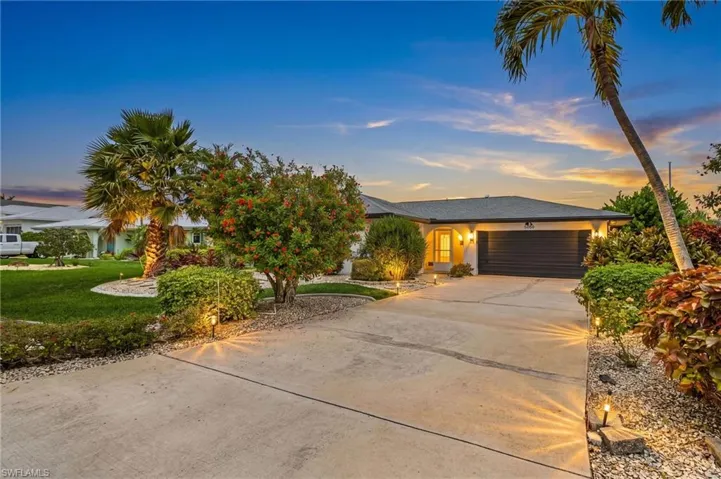 Concrete driveway with perimeter landscaping and accent lighting