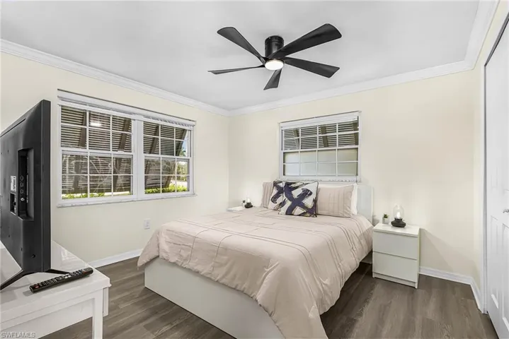 Bedroom with ceiling fan, wood-finish flooring and good sized closet.