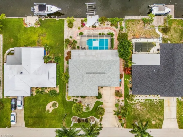 Aerial view of home with pool, boat dock and boat lift.