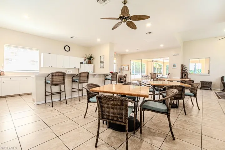 room with a wealth of natural light, ceiling fan, and light tile patterned flooring, kitchen and ample seating