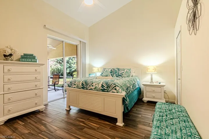 Bedroom featuring access to exterior, high vaulted ceiling, ceiling fan, and dark wood-type flooring