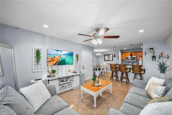Living room with light tile patterned floors and ceiling fan