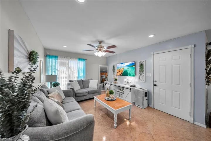 Tiled living room featuring ceiling fan