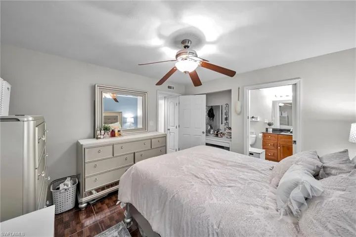 Bedroom featuring ceiling fan, connected bathroom, and dark hardwood / wood-style floors