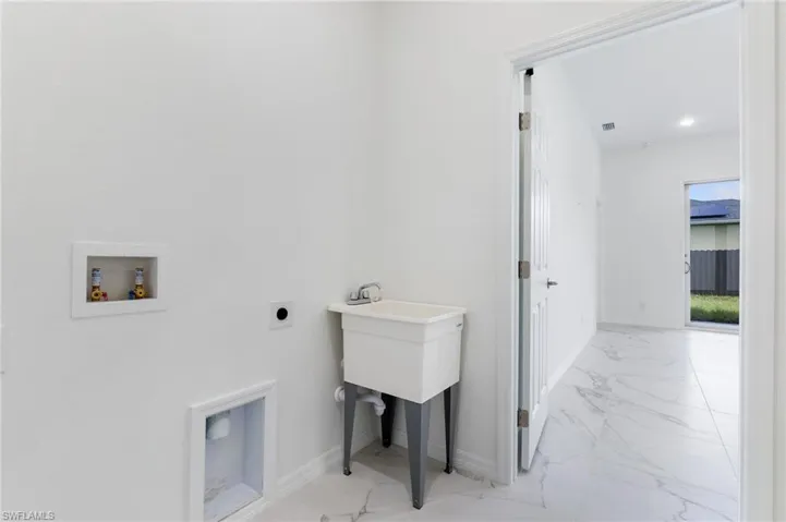 Clothes washing area featuring hookup for a washing machine and electric dryer hookup