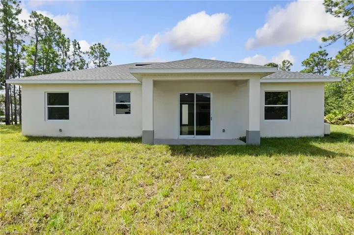 Rear view of house featuring a lawn