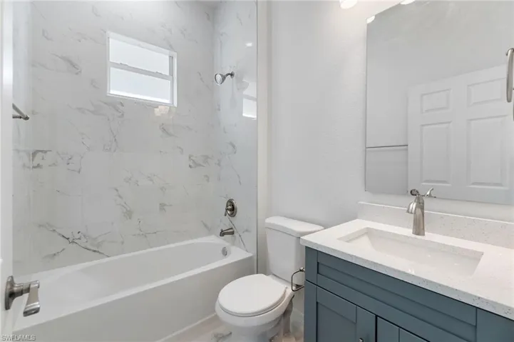 Full bathroom featuring vanity, toilet, and tiled shower / bath combo