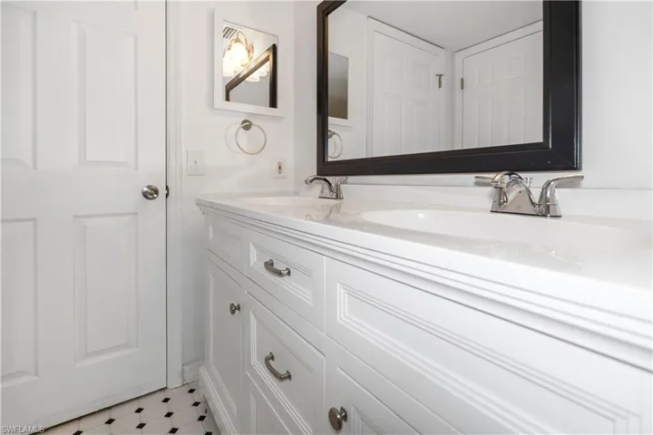 Full bathroom with double vanity and light floors