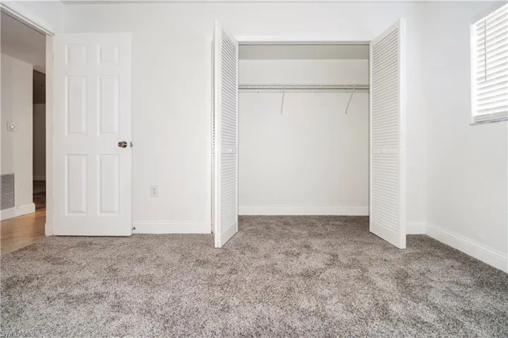 Unfurnished bedroom featuring a closet and light colored carpet
