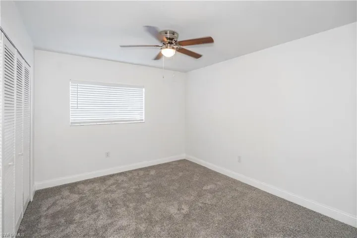Unfurnished bedroom featuring a closet, carpet flooring, and ceiling fan