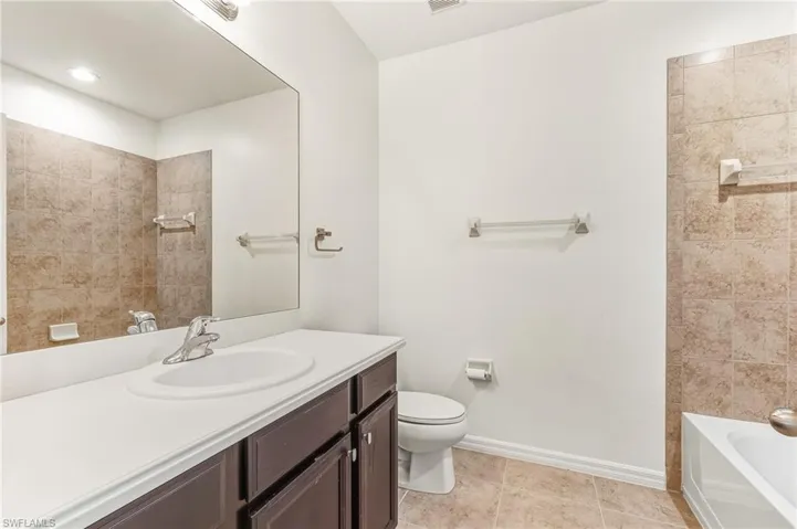 Full bathroom featuring vanity, light tile patterned flooring, and  shower combination