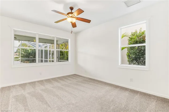 Empty room with carpet flooring and a ceiling fan