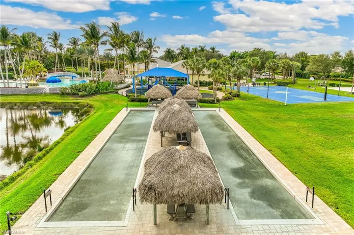 View of property's community featuring a yard, a game area, and a water view