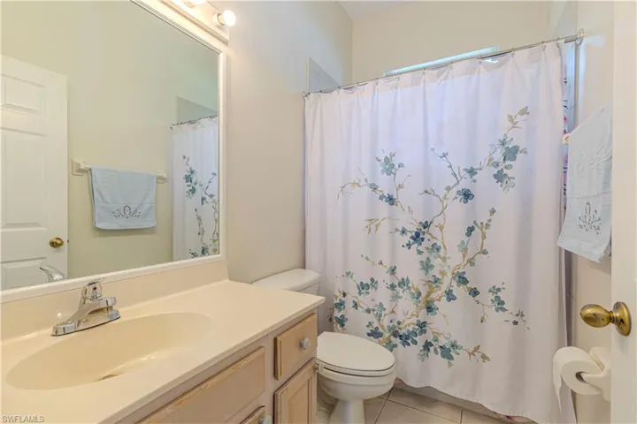 Bathroom with tile patterned flooring, vanity, toilet, and walk in shower