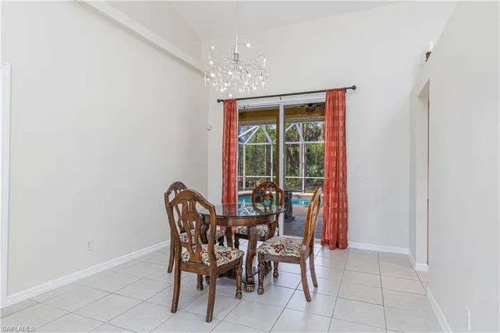 Tiled dining area with vaulted ceiling and a notable chandelier
