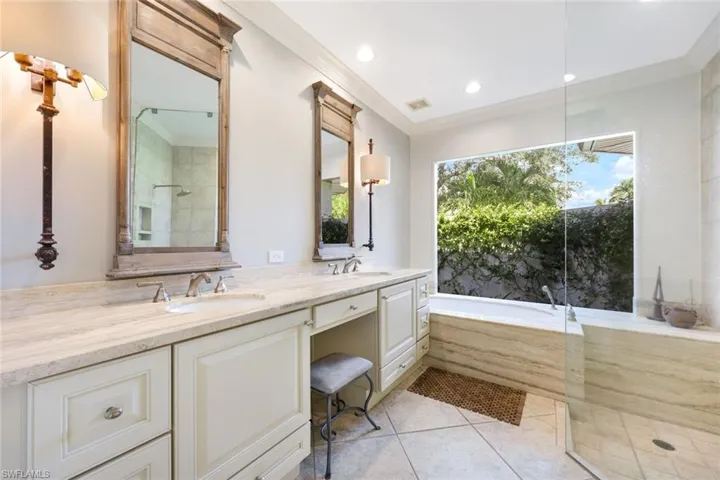 Well-appointed bathroom with luxury and practicality. Features spacious, separate shower and soaking tub. Double vanity provides ample counter space. Privacy picture window allows natural light.