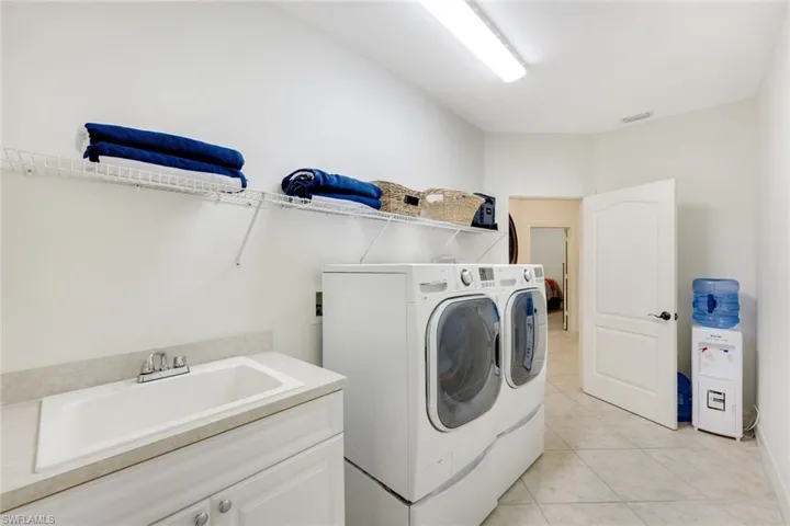 Laundry area with light tile patterned floors and washing machine and dryer
