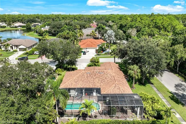 This captivating aerial shot showcases the expansive property, with a particular emphasis on the pool area, making it a standout feature of the home.