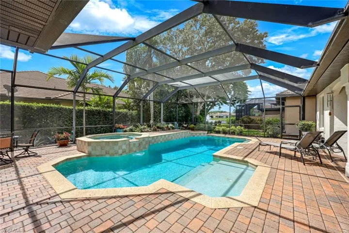 Enjoy the beautiful paver pool deck, relax in the heated salt water pool, and unwind in the comfortable screened-in lanai, perfect for outdoor enjoyment and relaxation.