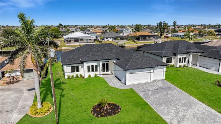 View of front of home with french doors, roof with shingles, driveway, and a residential view