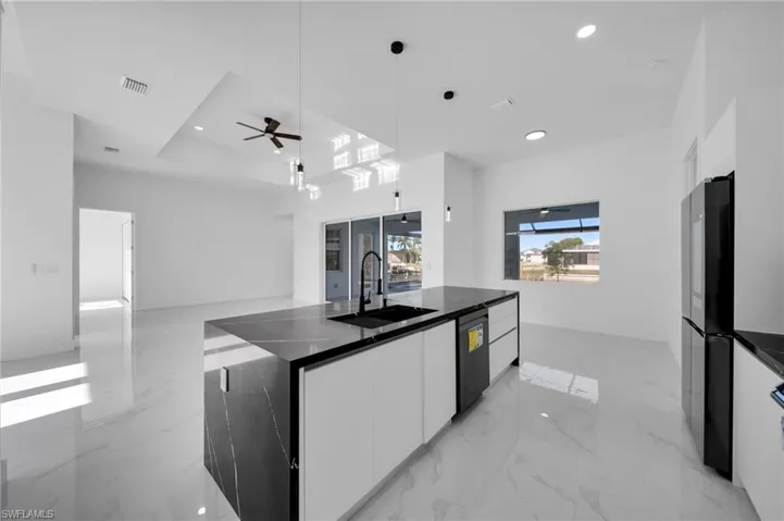 Kitchen with visible vents, modern cabinets, white cabinetry, a sink, and dishwasher