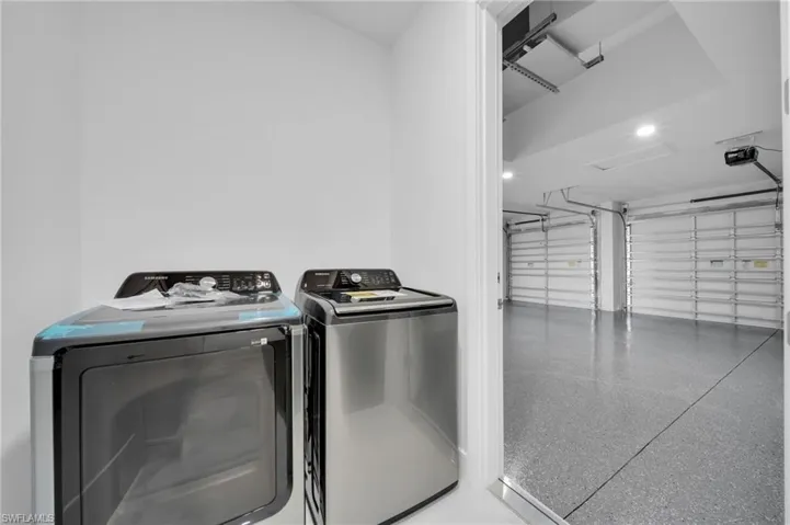 Laundry room with a garage and washing machine and clothes dryer
