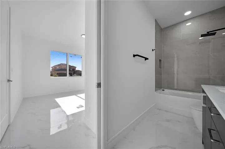Bathroom with toilet, baseboards, marble finish floor, and vanity