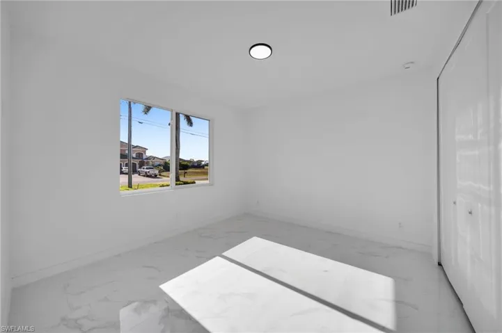 Spare room with baseboards, visible vents, and marble finish floor