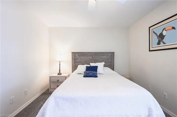 Bedroom featuring dark carpet and baseboards