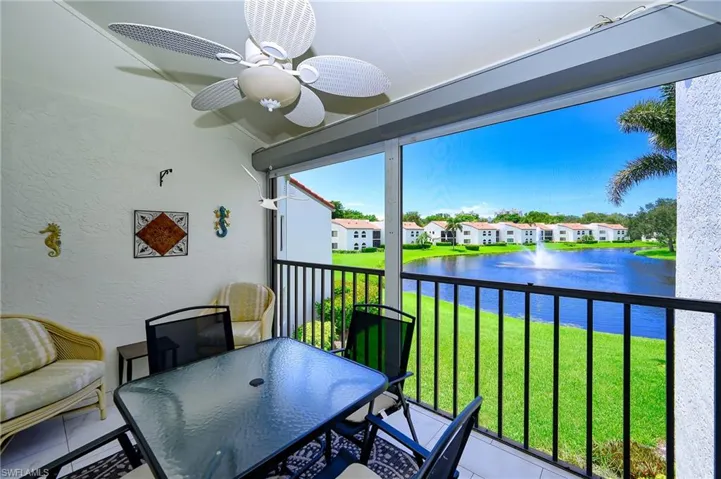 Balcony featuring a water view, a sunroom, outdoor dining area, and ceiling fan