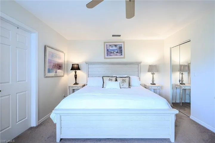 King size Bed in master bedroom with ceiling fan, a closet, and carpet flooring