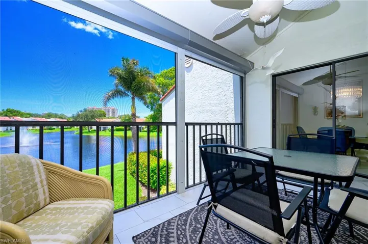 Balcony featuring a water view, a sunroom, and a ceiling fan
