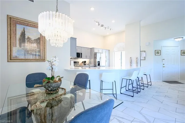 Dining space with light marble finish flooring and a chandelier