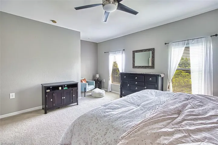 Spacious room featuring light-toned carpeting and multiple windows with blinds