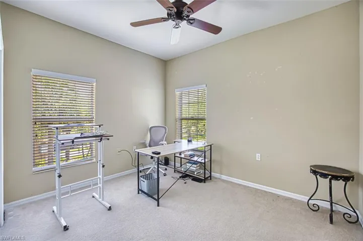 Room featuring vaulted ceilings, two windows with horizontal blinds, neutral wall paint, and light-colored carpet