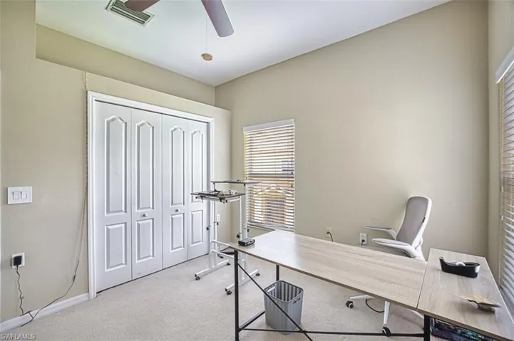 Vaulted ceiling room featuring a ceiling fan with light fixture, carpet flooring, bi-fold closet doors, and window with horizontal blinds