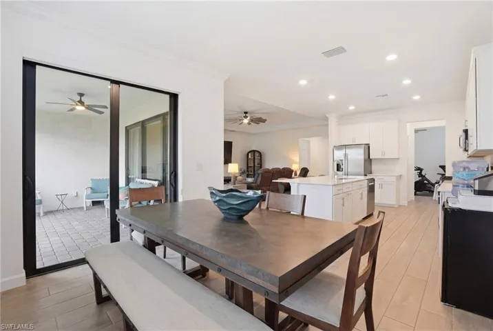 Dining area featuring ceiling fan, ornamental molding, recessed lighting, and light wood-style floors