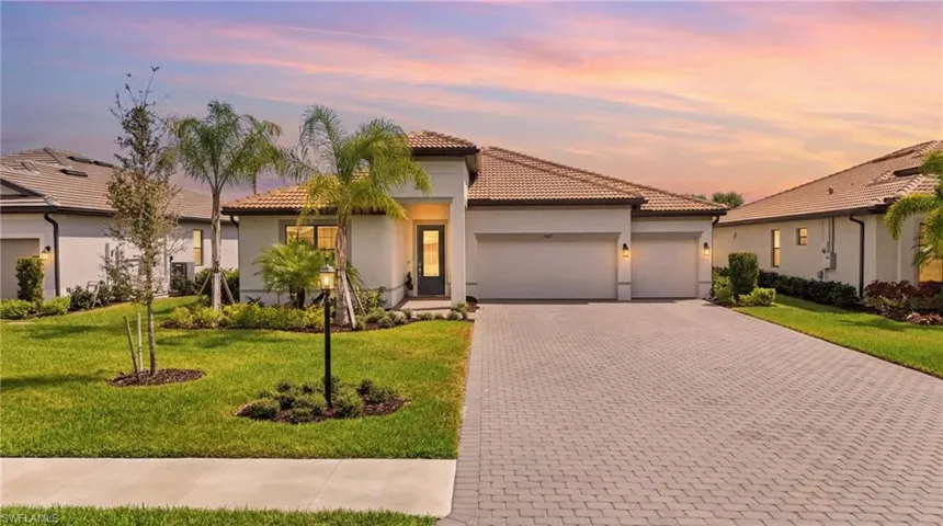 Mediterranean / spanish-style home with an attached garage, stucco siding, a yard, driveway, and a tile roof